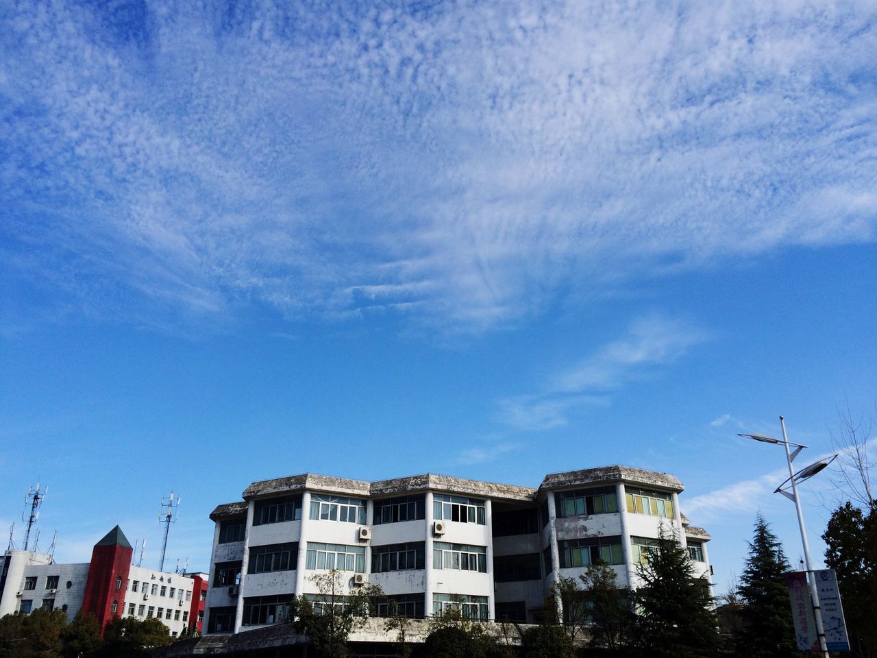 building exterior, architecture, built structure, low angle view, sky, blue, building, residential building, city, residential structure, cloud - sky, house, day, cloud, tree, outdoors, no people, street light, sunlight, high section