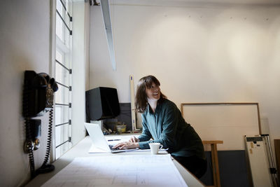 Woman working with smart phone sitting on table