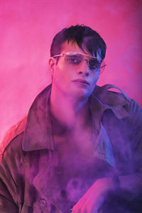 Portrait of young man against pink background