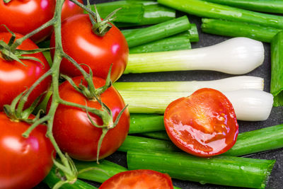 Close-up of cherry tomatoes and scallion on table