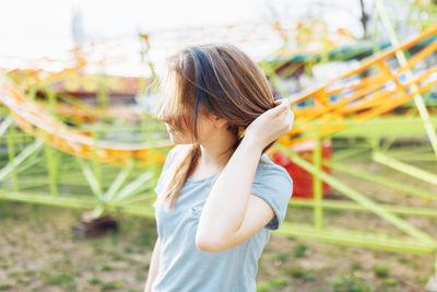 Happy young gen z woman with trendy blue hair in an amusement park. summer, sunlight