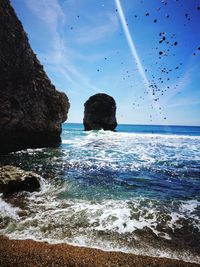 Rocks in sea against sky