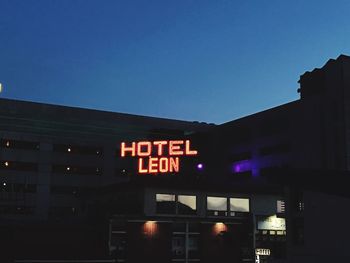 Low angle view of illuminated building against clear blue sky