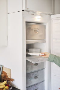 Woman's hand taking ice cubes out of freezer