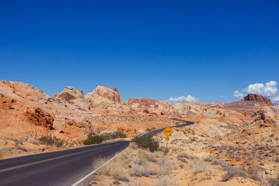 Empty road and rock formations against sky at valley of fire state park