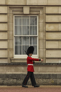 Full length of boy standing against wall