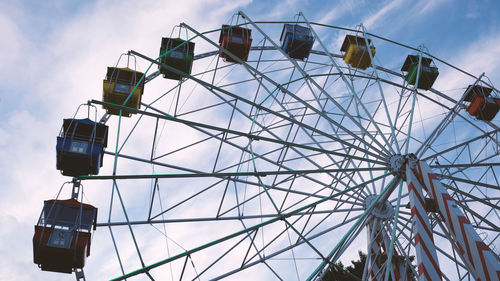 Colorful ferris wheels in the amusement park on a background of blue sky with clouds. toned image. 