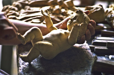 Cropped hand of woman holding statue in shop