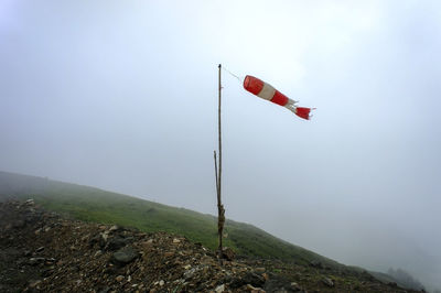 Old striped red-white windsock, indicator of strength and direction of wind in mountains in fog