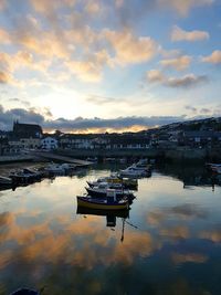 Boats moored in harbor against buildings in city