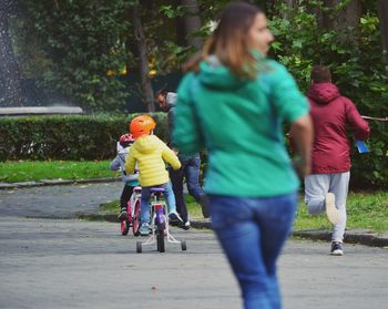 Rear view of people riding bicycle