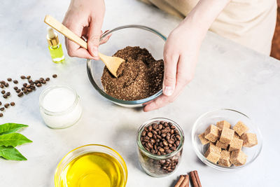 Woman mixing ingredients preparing coffee scrub for skin treatment