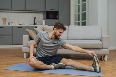 Side view of boy sitting on sofa at home