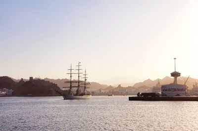 Scenic view of a sailing ship performing maneuvers to moor in the port of muscat in oman