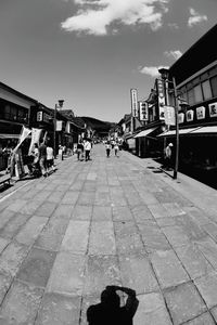 People on street in city against sky