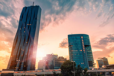 Low angle view of modern buildings against sky during sunset