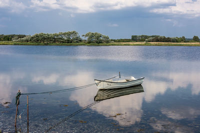 Rowboat and reflection in water on island helnaes, denmark