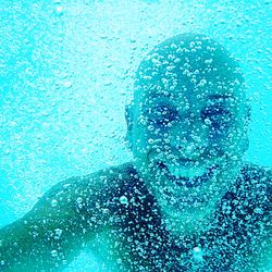 Close-up portrait of a man swimming underwater