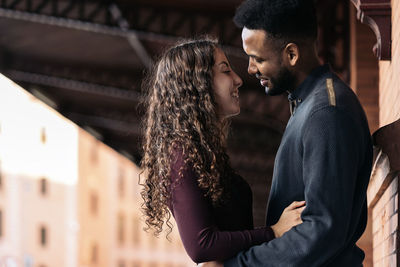 Side view of young couple embracing outdoors