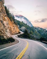 Road by mountains against sky