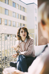 Smiling young woman sitting outdoors