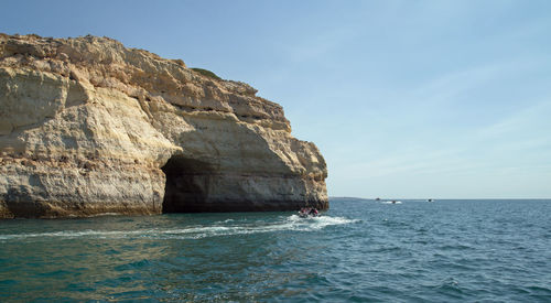 Rock formation in sea against sky