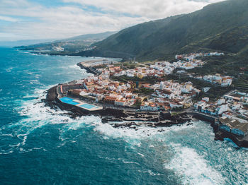 High angle view of sea by buildings against sky