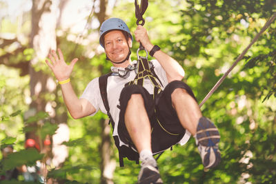 Portrait of man hanging from tree