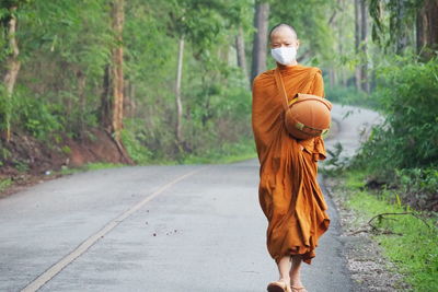 Rear view of man walking on road