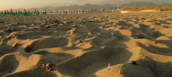 Shadow on sand at beach against sky