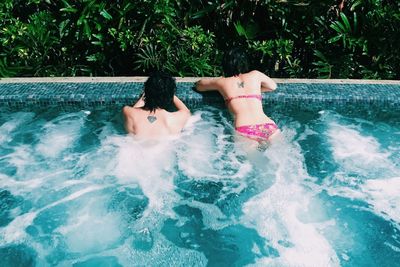 Rear view of young woman in swimming pool