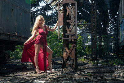 Portrait of woman standing in old abandoned rusty train yard
