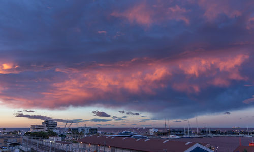 Panoramic view of buildings against dramatic sky during sunset