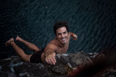 Portrait of smiling young man on rock