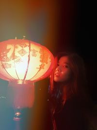 Close-up of young woman in illuminated lantern