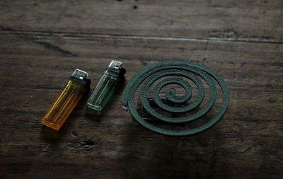 Close-up of mosquito coil with cigarette lighter on table