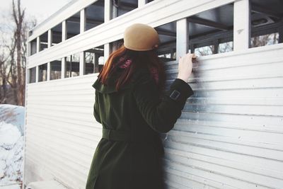 Rear view of woman standing by railing