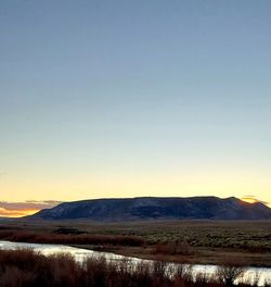 Scenic view of landscape against clear sky during sunset