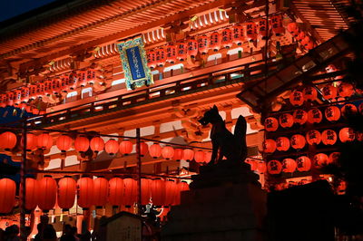 Low angle view of illuminated lanterns hanging in temple at night