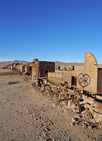 Old ruin on field against clear blue sky