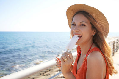 Beautiful girl eating a popsicle on promenade beach