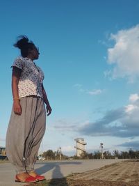 Woman standing on land against sky