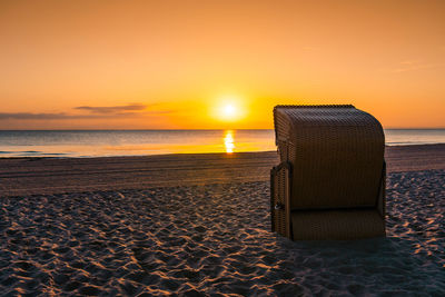 A typical german strandkorb at the beach of scharbeutz during sunrise.