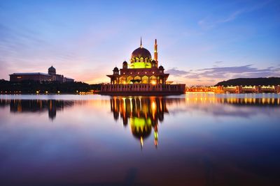 Reflection of church in front of water against sky