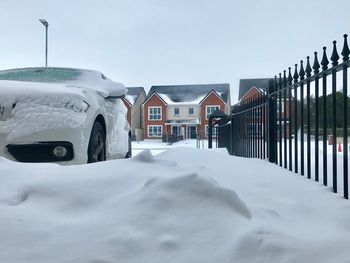 Snow covered houses against sky