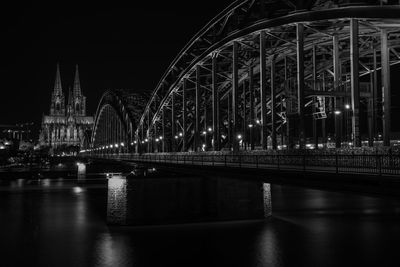 Illuminated bridge over river at night