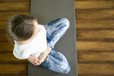 Rear view of boy sitting on wooden floor