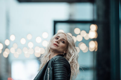 Portrait of young woman looking up outdoors