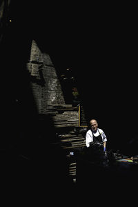 Full length of man sitting at temple against building