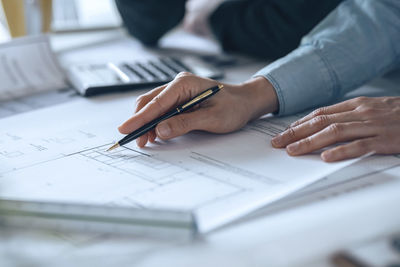 Businesswoman holding pen over diagram on paper